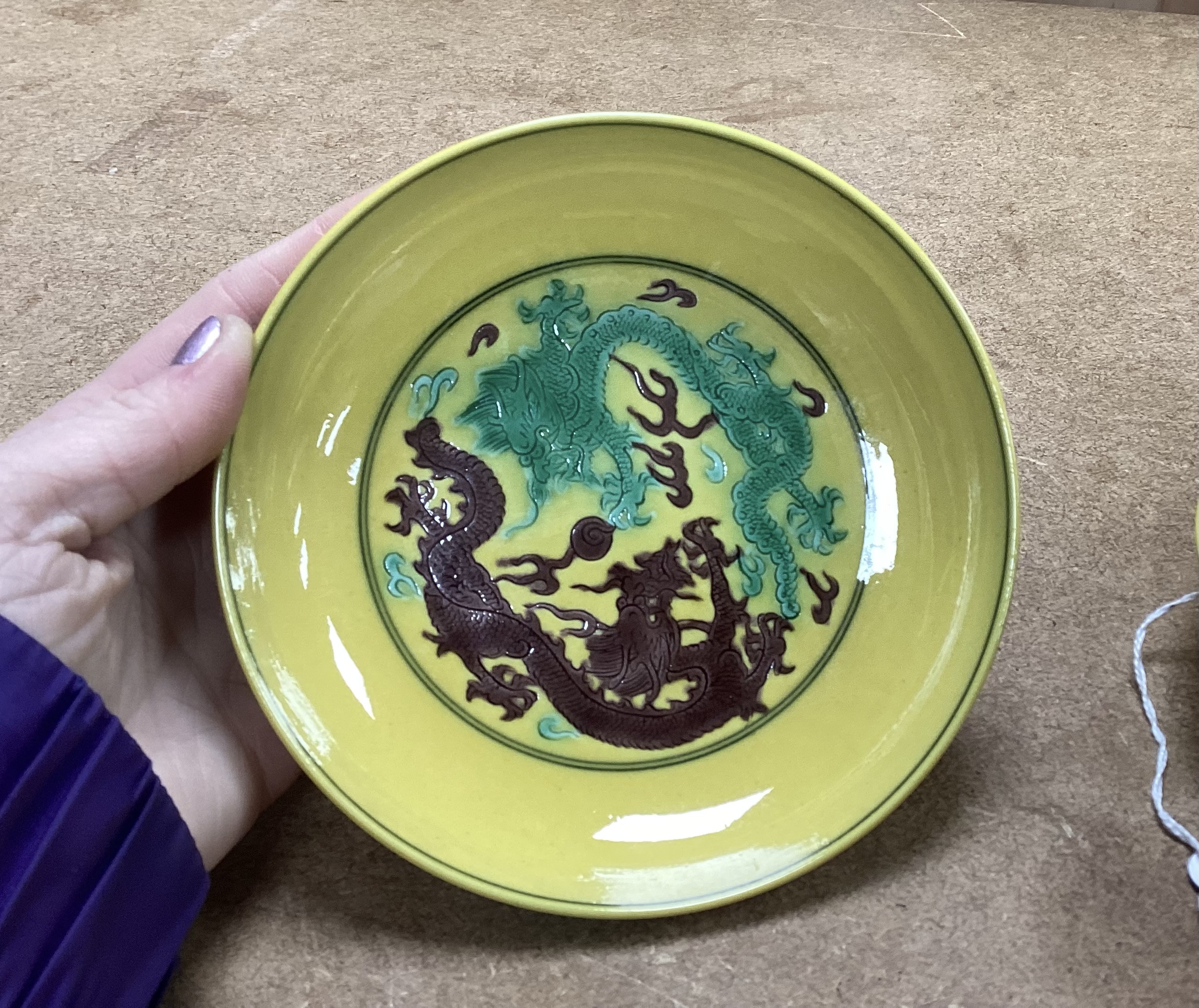 A pair of Chinese yellow glazed ‘dragon’ dishes, 13cm in diameter